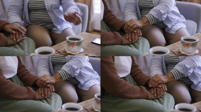 4k视频，一名女子在家里的沙发上喝咖啡时，与年迈的亲戚手牵手