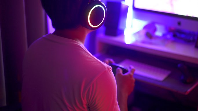 特写亚洲年轻男子游戏玩家在夜间4K RT玩在线电脑游戏