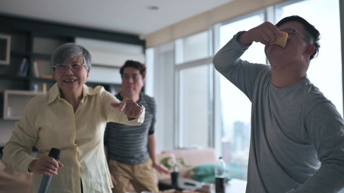 多代亚裔华裔男子周末在客厅与唐氏综合症儿子跳舞，与祖母唱歌跳舞，玩得很开心