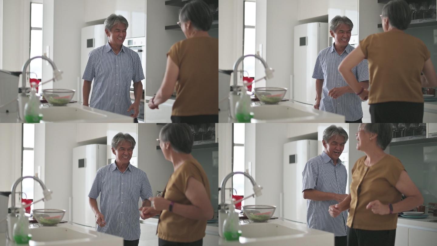 亚裔中国老年夫妇周末在家做饭时喜欢在厨房跳舞