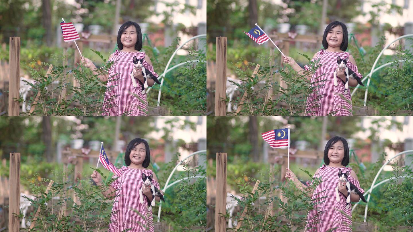 一名亚裔中国女孩，她的宠物猫在自家农场挥舞国旗
