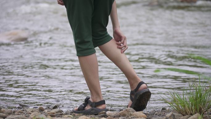 亚洲女子在河边抓腿