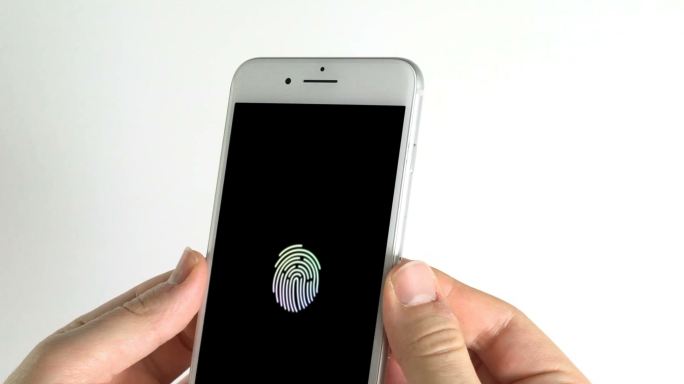 男人用智能手机和彩色指纹在屏幕上扫描黑色背景的手指