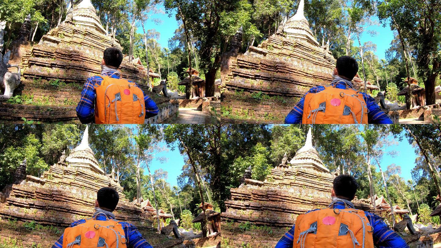 亚洲男子游客背着背包走进寺庙
