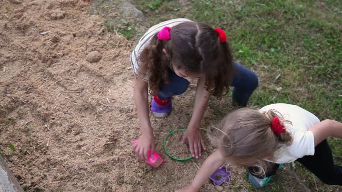 两个小女孩在院子里争夺玩具