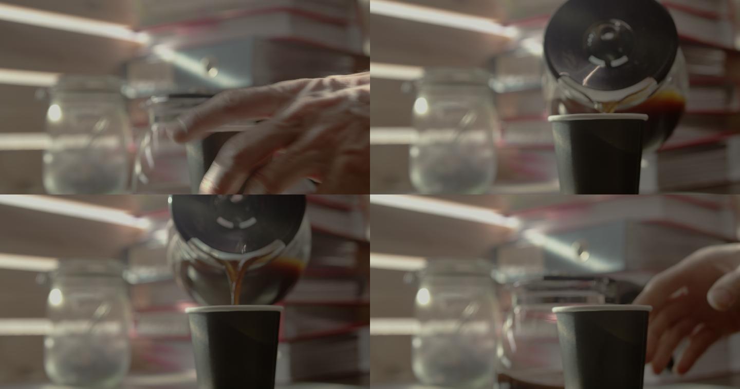 特写镜头：一名男子把手伸向咖啡壶，将黑咖啡倒入纸杯