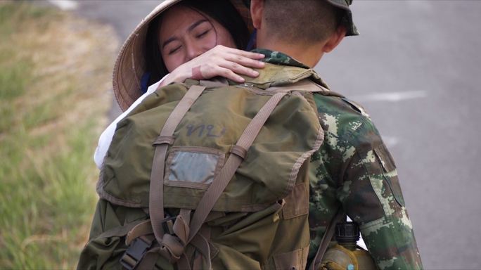 穿着传统白色敖黛服装的女人越南传统服装。女朋友拥抱士兵，征兵。