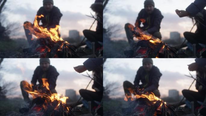 一家人在篝火中烤香肠。冬天的乐趣。城市的河边
