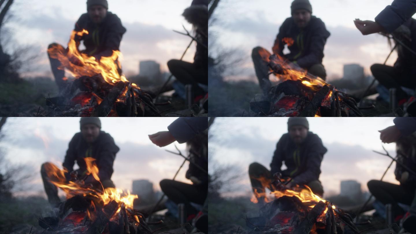 一家人在篝火中烤香肠。冬天的乐趣。城市的河边
