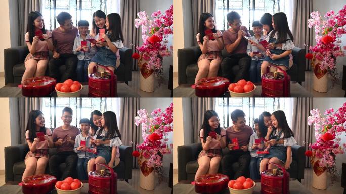 在中国新年的第一天，快乐的亚洲父母在家给他们的孩子发红包