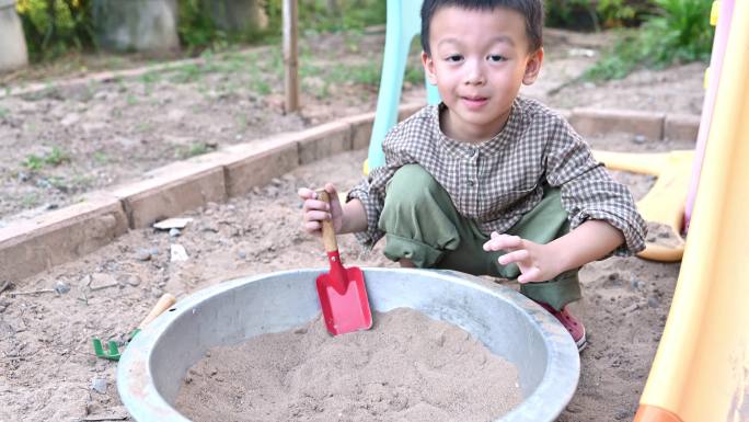 亚洲男孩正在沙盒里玩沙子