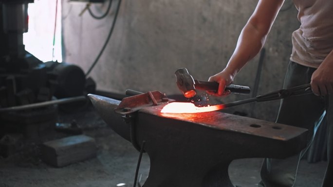 铁匠在铁砧上锻造金属