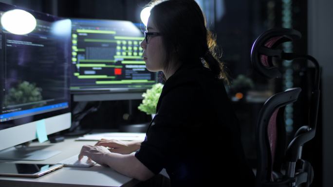 女性IT工程师在夜间工作并编写程序