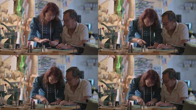 一对亚裔华裔老夫妇在工作室里制作手工皮革表带