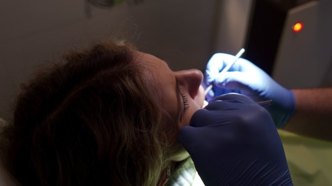 牙医在检查时使用斜镜和牙科探针