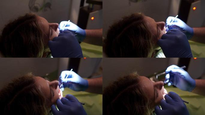 牙医在检查时使用斜镜和牙科探针