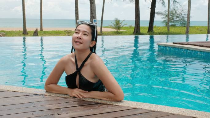 无忧无虑的女人在游泳池里放松暑假的概念