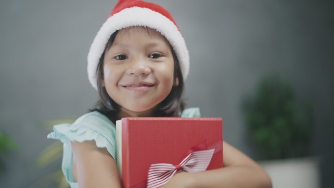 戴着圣诞老人帽子的小女孩得到了空礼物盒。