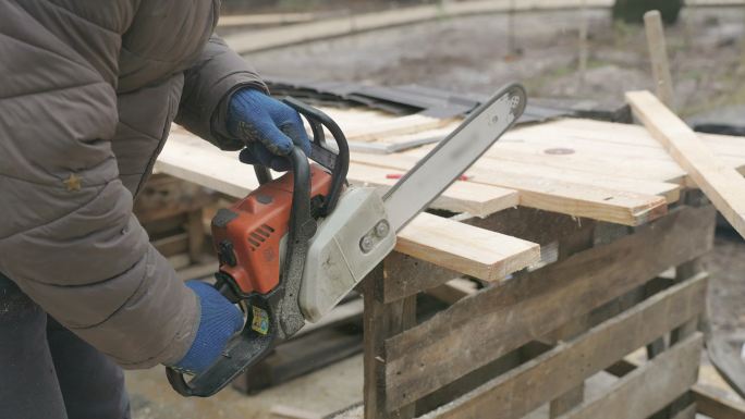 木匠用电锯锯切松木板。