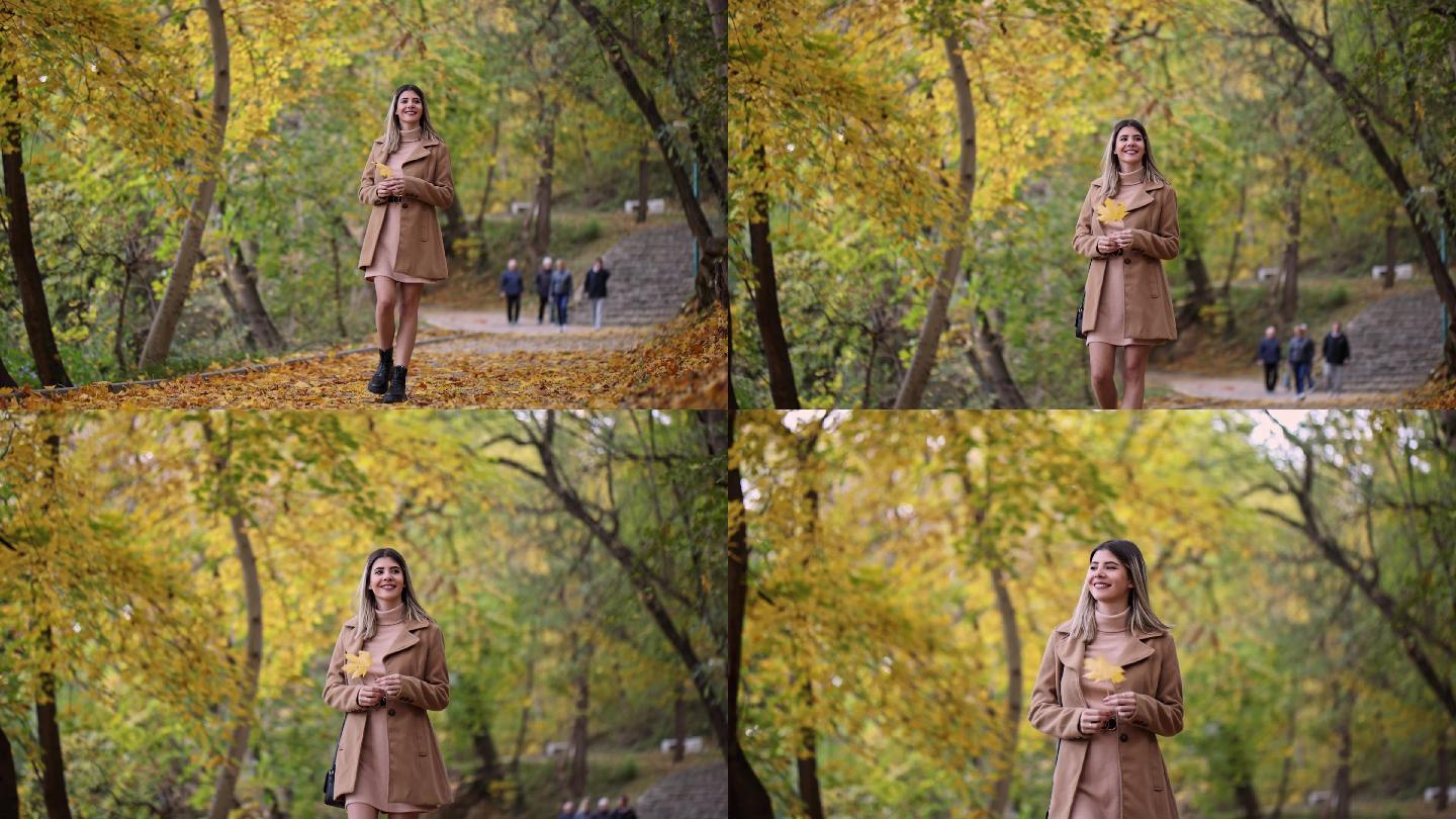 美丽的女人漫步在秋色的公园里