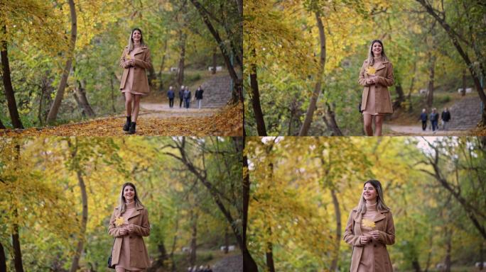美丽的女人漫步在秋色的公园里