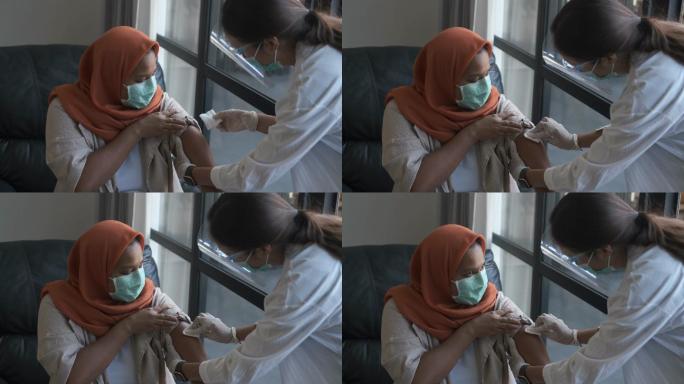 印尼医护人员在患者上臂擦拭酒精擦拭物