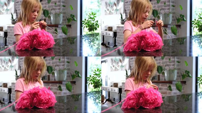 用粉色羊毛编织的年轻女孩