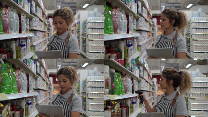 在超市工作的美女用条形码扫描仪和平板电脑清点存货