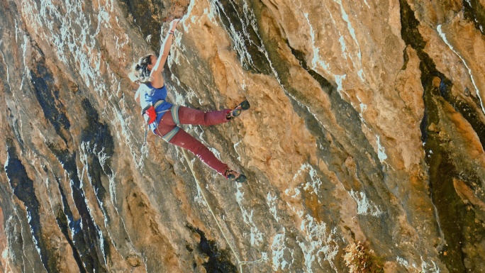 在比利牛斯山脉攀登的年轻女性攀岩者