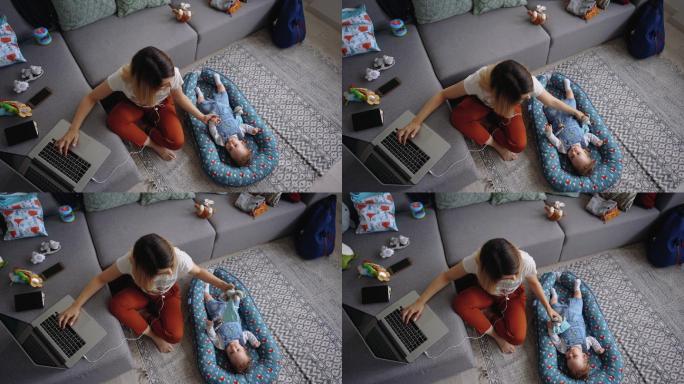 年轻的单身母亲在家工作，她的儿子躺在她身边