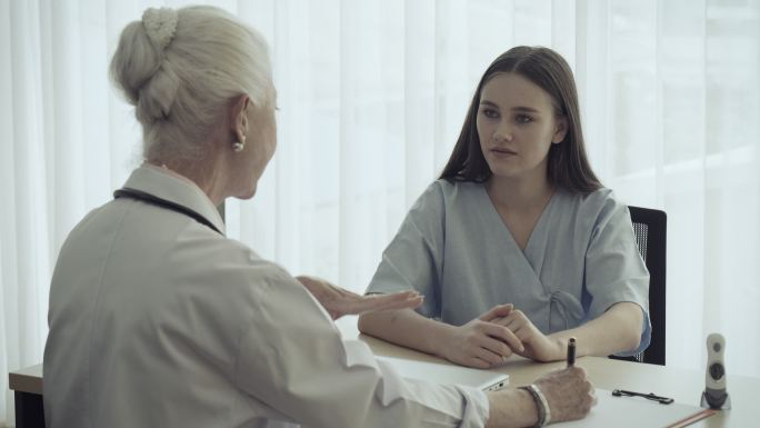 精神科医生女医生在医院为女病人提供咨询服务。2019冠状病毒疾病效应，