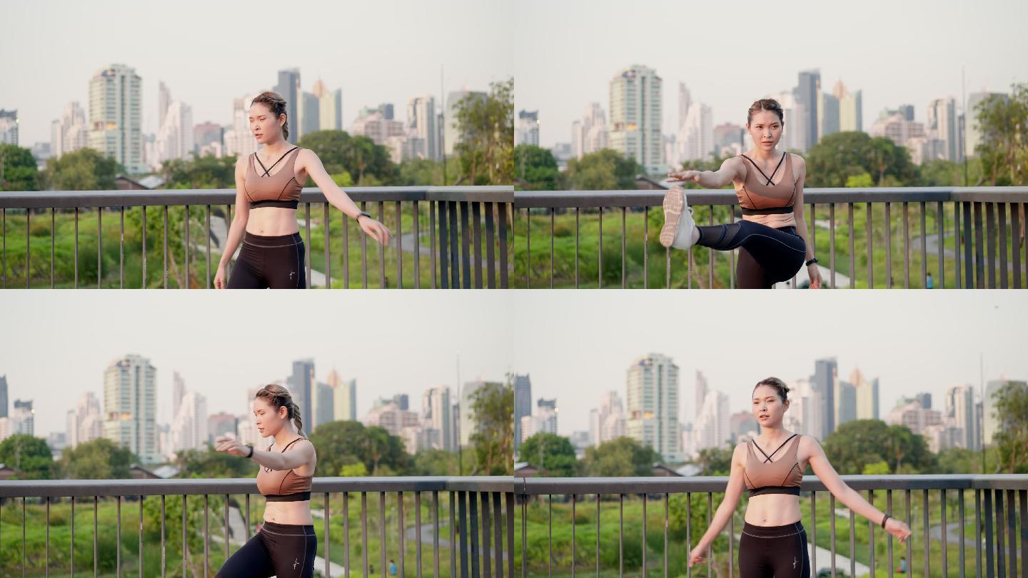 亚洲美丽的中年女性，穿着运动服，早上在城市公园的人行天桥上锻炼后，通过伸展腿部和手臂肌肉，达到完美的