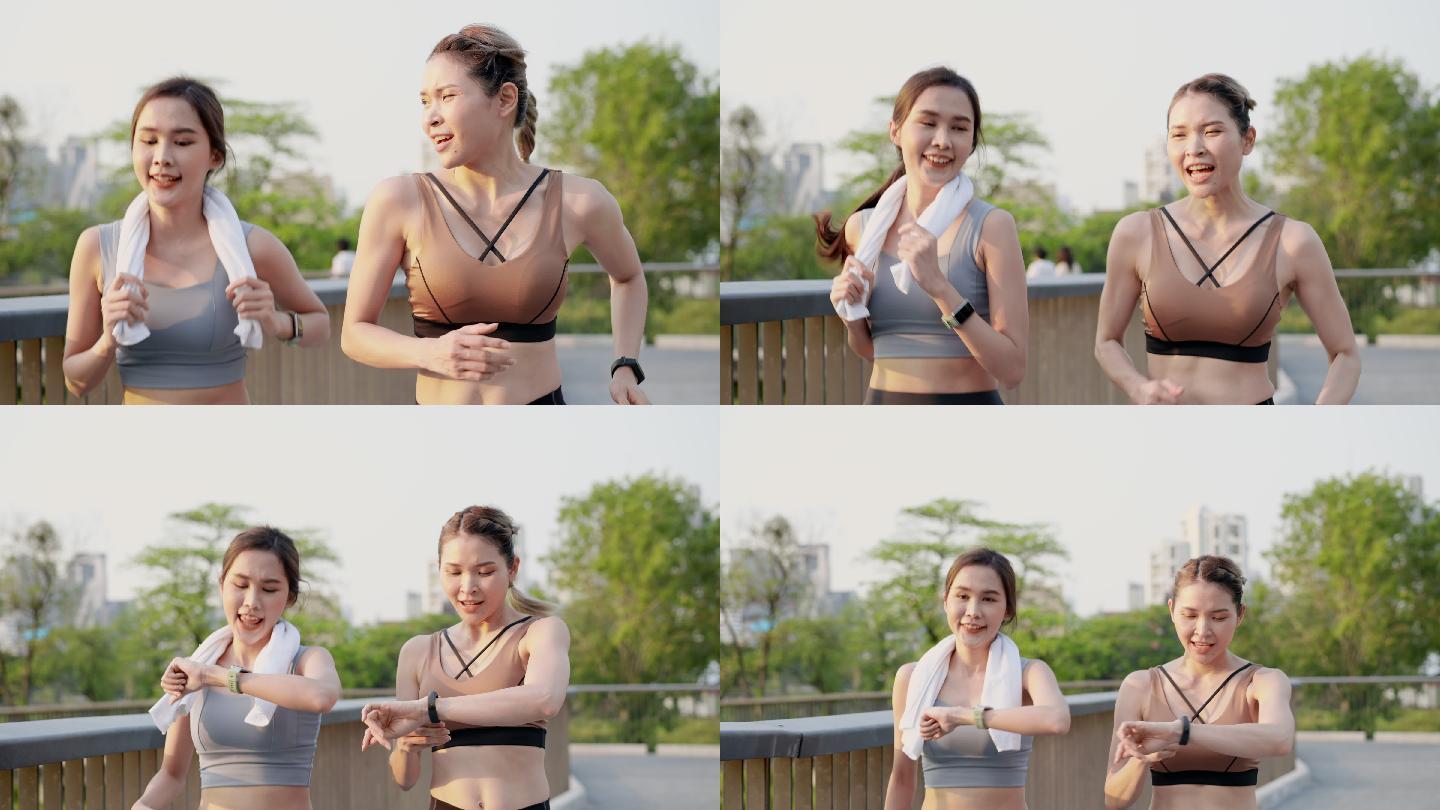 正面图：两位亚洲美丽的中年女性朋友穿着运动服，肌肉完美，一起积极慢跑，使用智能手表监控，早上在市中心