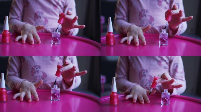 卷曲的美丽小女孩用儿童指甲油涂指甲