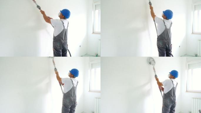 房屋油漆工在油漆前用砂纸打磨墙壁。