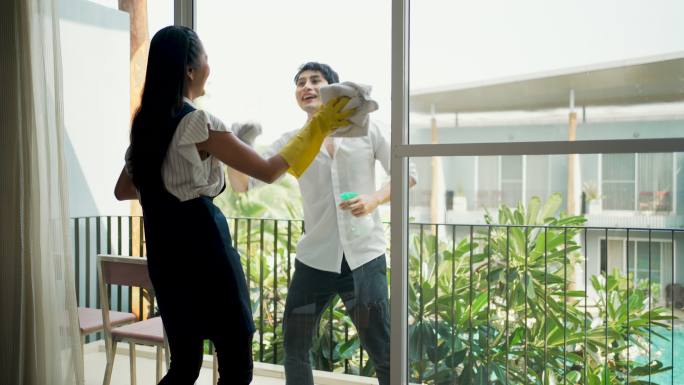 年轻的亚洲异性恋夫妇一起帮忙打扫房子。