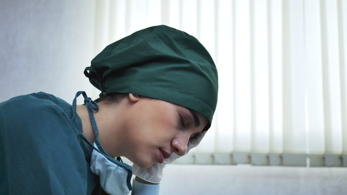 一幅女性医护人员在艰难的一天中休息的照片。