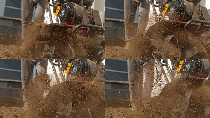 TIME WARP SLO MO Gardener使用前齿耕耘机犁过坚硬的泥土和土壤