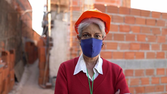 一名女性建筑工人在施工现场使用防护口罩的肖像