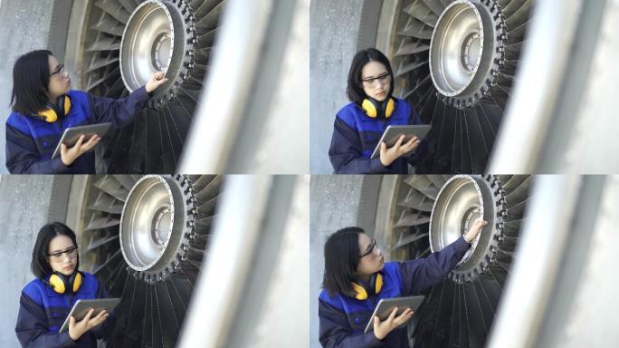 女飞机工程师在机场使用数字平板电脑检查喷气式发动机