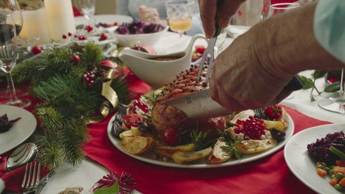 一家人正在享用圣诞晚餐，配上带丁香的上釉节日火腿、蔬菜、肉馅饼和蛋奶酒橙色小点心