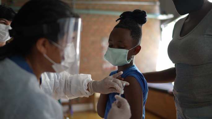 男孩在诊所接种疫苗——使用口罩