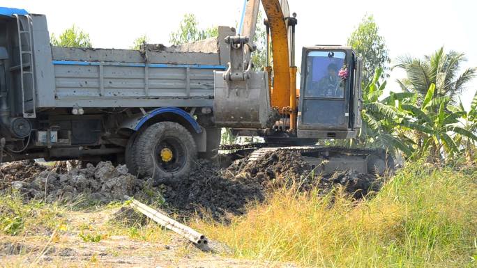 特写镜头：泥潭中的推土机推卡车