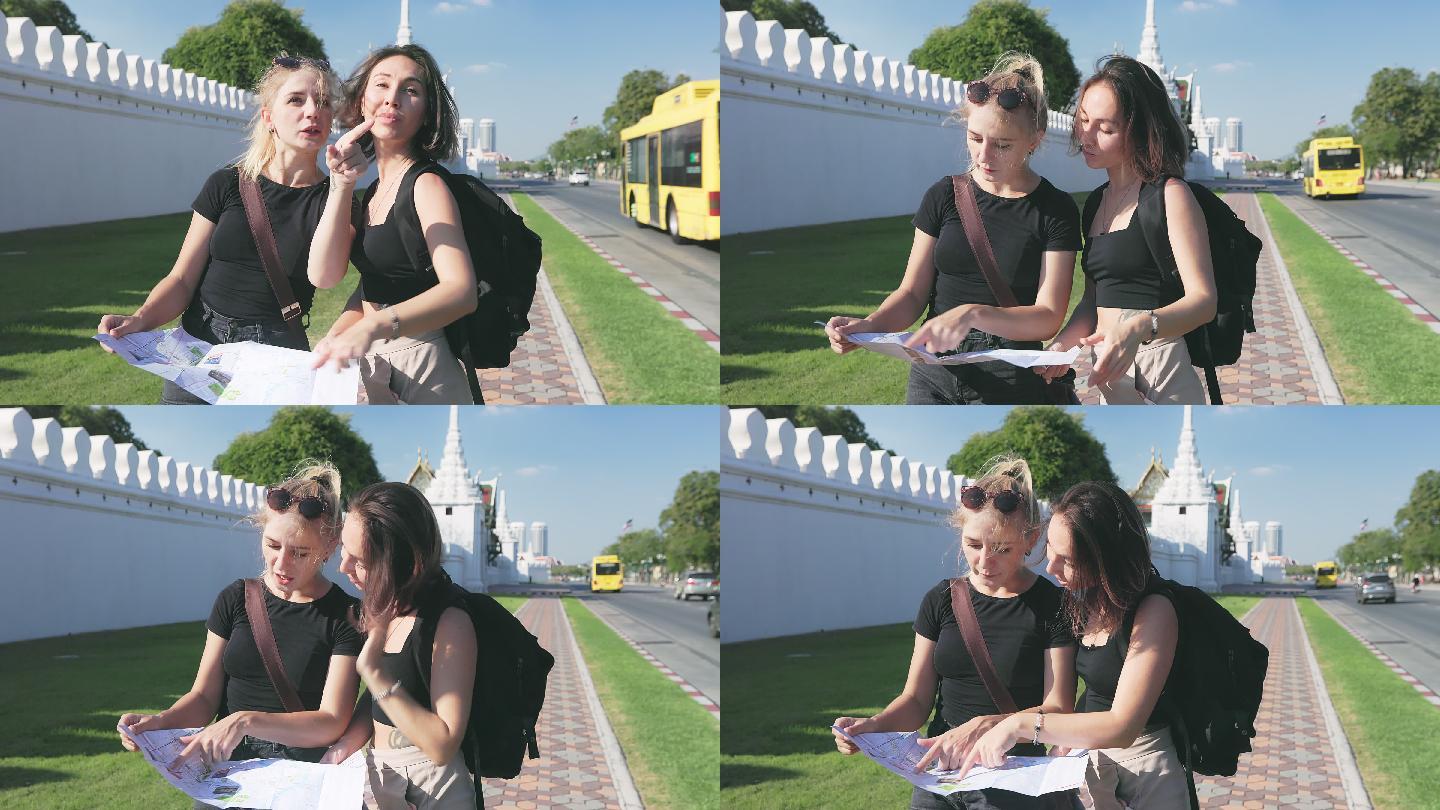 两名年轻的白人白人女游客在曼谷探索时使用地图进行讨论。