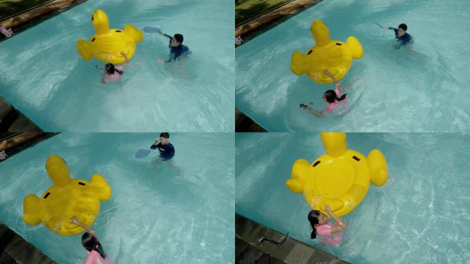 快乐的亚洲孩子和家人一起在酒店或度假村的泳池里玩黄鸭橡皮筏，生活方式理念。