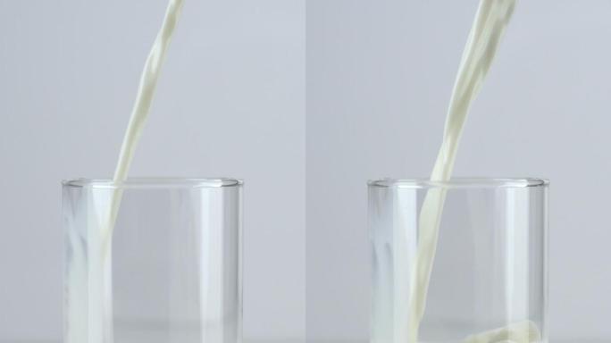 垂直和慢动作：将牛奶倒入白色背景的玻璃杯中。