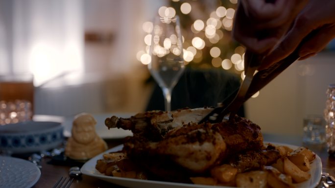 圣诞节期间在餐桌上切烤鸡的女人
