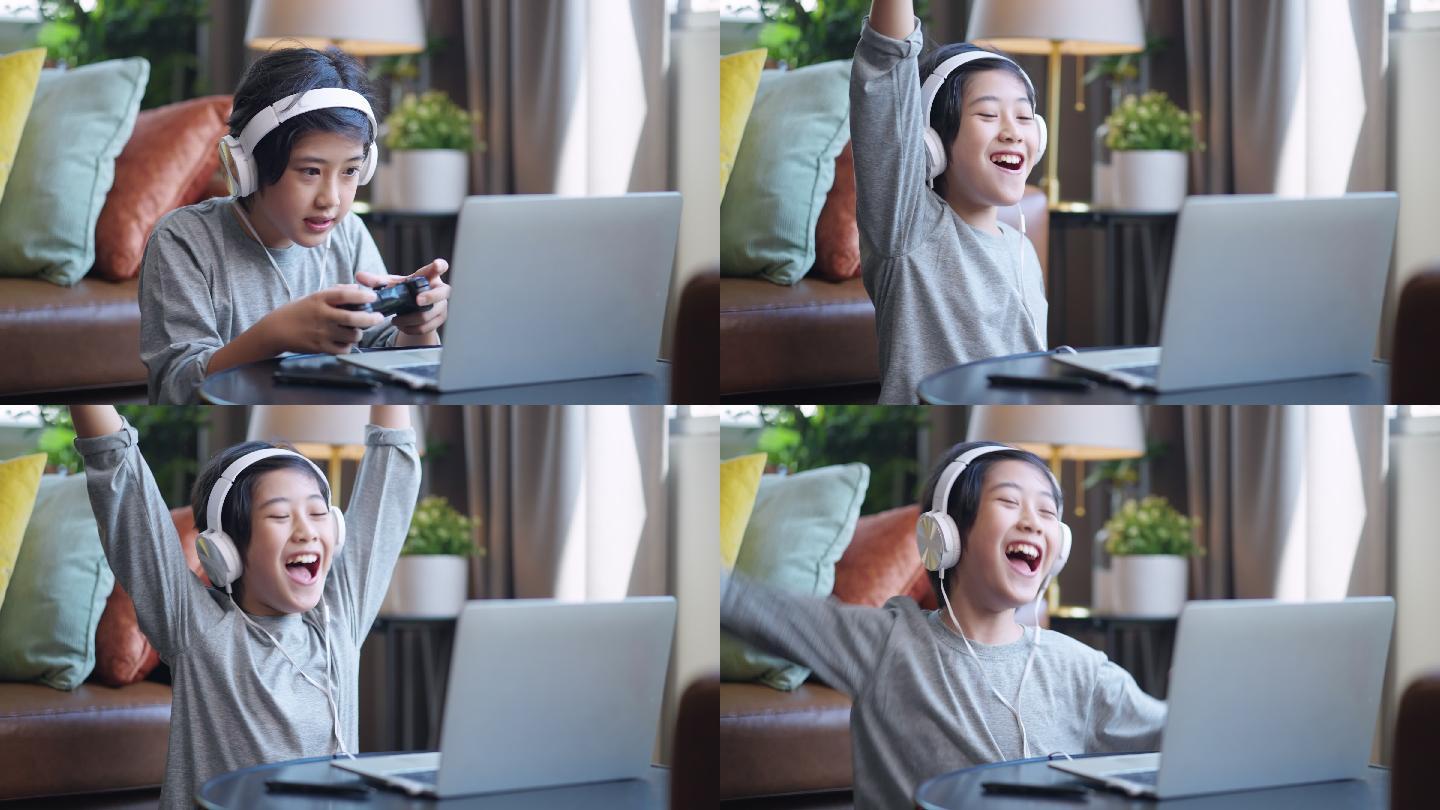 周末假期，亚洲男孩戴着耳机，玩着笔记本电脑游戏，坐在客厅的地板上玩着开心的游戏，儿子独自玩着移动设备