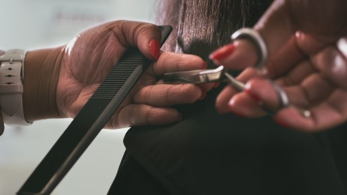 一段4k视频，一位面目全非的女子坐在一家沙龙的理发师那里理发