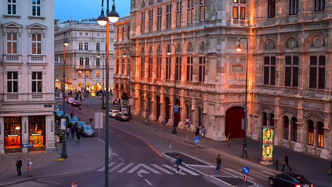 奥地利维也纳，交通道路和人们在维也纳歌剧院前散步的日落场景